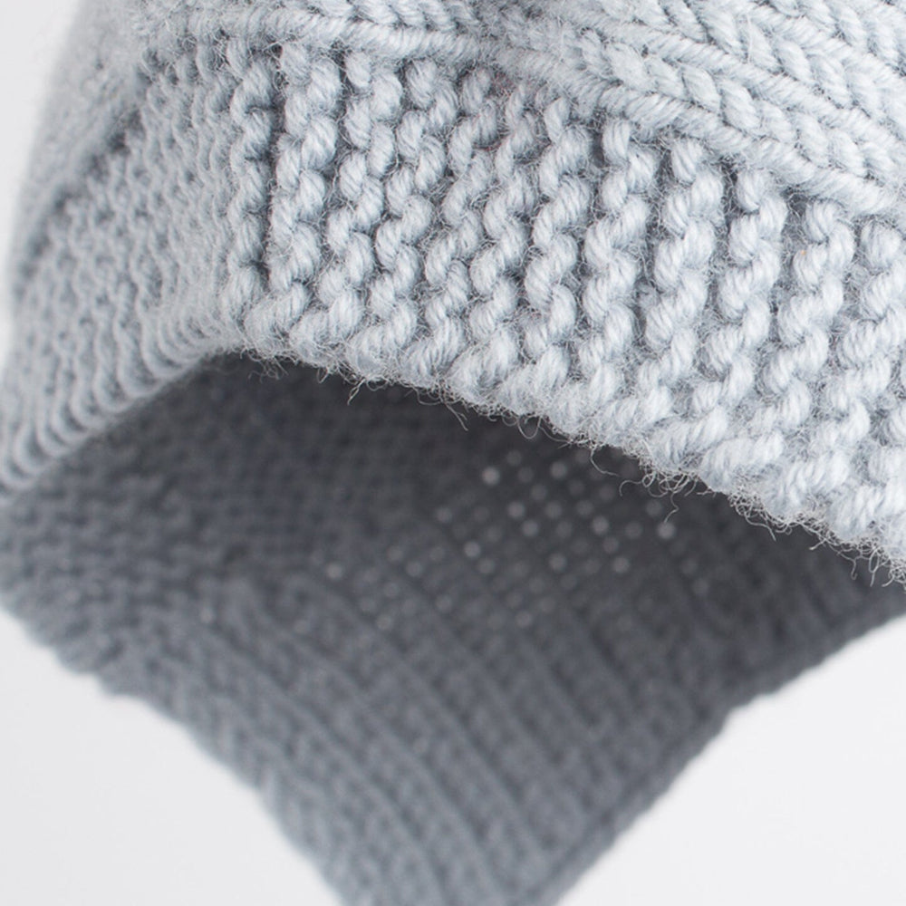 Detalle de capote de bebé azul hecha a mano con lana merino, de ÁBBATTE