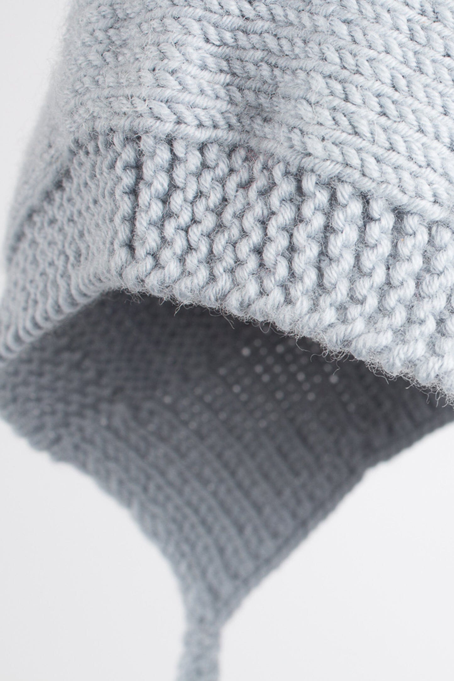 Detalle de capote de bebé azul hecha a mano con lana merino, de ÁBBATTE