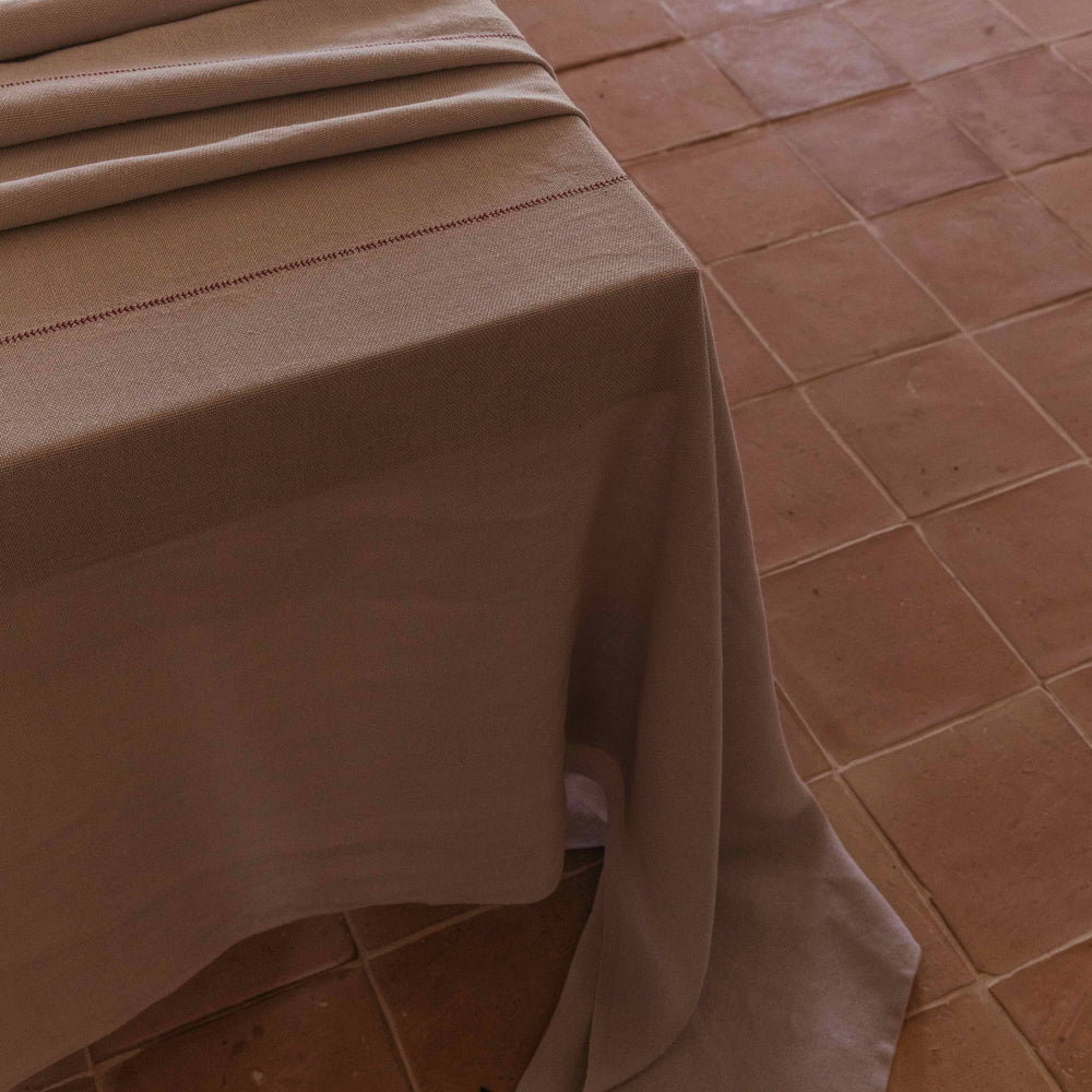
                  
                    Mantel de lino malva hecho a mano en España, de ÁBBATTE.
                  
                