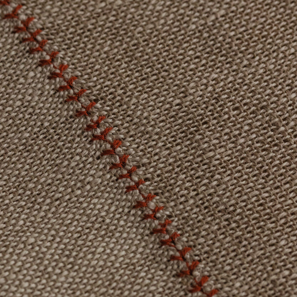 
                  
                    Detalle de mantel de lino hecho a mano en España con uniones en forma de palmera. De ÁBBATTE.
                  
                